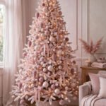 Pastel pink Christmas tree ideas: a dreamy pink tree with blush ornaments, rose gold accents, warm lights and a pink bow topper in an elegant living room
